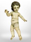 An 18th century German carved and painted wood putto, length 40 cm.