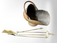 A Victorian copper coal helmet, together with a brass companion set.