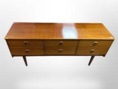 A 20th-century teak six-drawer dressing table, lacking mirror back,
