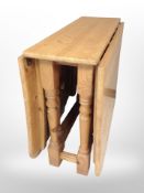 A contemporary pine drop-leaf dining table, extended 168cm long x 90cm wide x 76cm high,