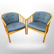 A pair of Danish bentwood armchairs with blue cushions.