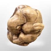 A large carved wooden figure of a man crouched with head in his hands, approximately 20 cm square.