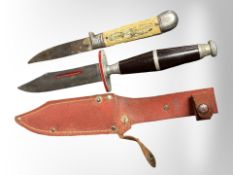 Two hunting knives, one in sheath.