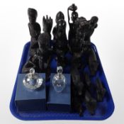 A group of African ebony carvings and two boxed crystal perfume bottles.