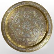 A Cairo ware brass charger with copper and silvered metal inlay, diameter 34cm.