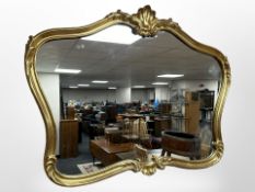 A contemporary ornate gilt-framed mirror, 102cm x 77cm.