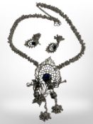 An ornate white metal pendant with enamel decoration on multi-ball link chain together with