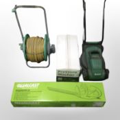 An electric lawn mower, hosepipe on reel, Qualcast electric hedge trimmer, and a pressure washer.