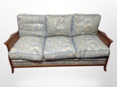 An early 20th-century mahogany-framed bergère three-piece lounge seat in floral upholstery,