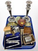 A group of metal wares including pair of ornate silver-plated candlesticks, cutlery, nutcrackers,