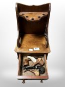 A mahogany pipe rack containing several pipes, width 23cm.