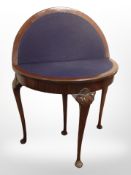 A carved mahogany demi lune table with baize lined interior,