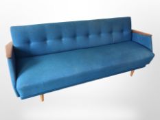 A 20th century Danish teak framed four seater settee in blue fabric,