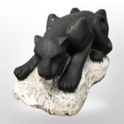 A painted hollow cast composition figure of a puma on rock,