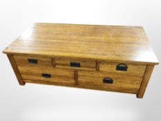 A reproduction oak veneered storage coffee table fitted drawers to both sides,