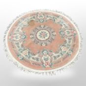 A Chinese circular rug on peach ground,