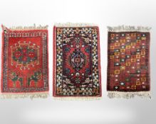 Three Afghan/Iranian hearth rugs, each approximately 45cm x 63cm.