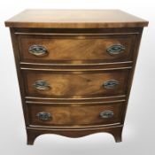 A reproduction mahogany bow-front three drawer chest in the Regency style,