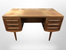 A 20th-century Danish teak and MDF twin-pedestal writing desk on tapered legs,