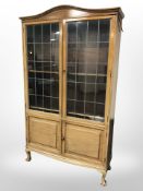 An early 20'th Century walnut leaded glass double-door cabinet, 111 cm x 35 cm x 189 cm.