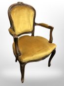 A continental carved beech salon armchair in mustard upholstery.