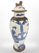 A Chinese blue and white crackle-glazed earthenware lidded vase depicting figures in traditional