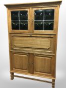 A 20th-century Danish blonde oak secretaire cabinet with stained leaded glass cabinet doors,