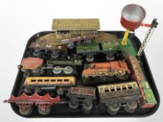 A group of vintage tin plate die-cast rolling stock, model railway platform, signalling sign, etc.