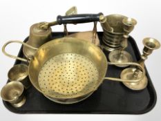 A group of brass wares including pestles and mortars, pair of candlesticks, wall-mounted bell,