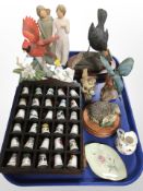 Two wooden racks containing porcelain thimbles,