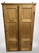 A 19th-century pine double-door wall cabinet with pigeon hole-shelved interior,