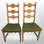 A pair of 20th-century Danish blonde oak ladder back dining chairs in striped upholstery.
