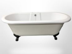 A composition roll top bath on cast metal paw feet,