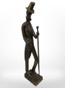 A hand-carved wooden figure of The Slim Man in top hat holding staff, height 42cm.