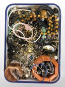 An enamelled tray containing a selection of costume jewellery, some silver pieces,