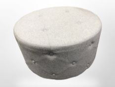 A contemporary circular stool in grey upholstery diameter 80 cm
