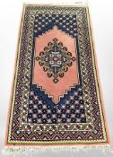 A Caucasian rug on pink ground, 162cm x 82cm.