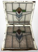 Two early-20th century stained and leaded glass windows in painted cast-iron frames,