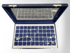 A jewellery display case containing assorted silver pendants.