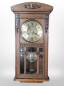 An early-20th century carved oak eight day wall clock, length 72cm.