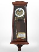 A reproduction wall clock with skeletonised movement, striking on a gong,