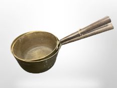 Two 19th century graduated brass and cast iron sauce pans.