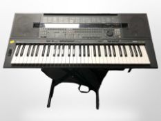 A Yamaha PS4-SQ16 digital keyboard on stand, with carry bag.