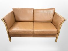 A contemporary Danish oak framed stitched tan leather two seater settee,