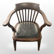 A stained beech elbow chair with black vinyl seat,