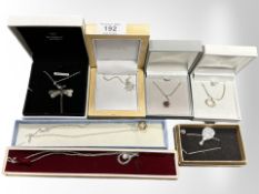 Seven silver pendants on chains, some set with gemstones.