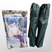 A garden hammock seat and a pair of folding chairs in carry bags