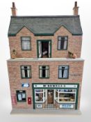 A doll's house with greengrocer's beneath containing doll's house furnishings and decorations,