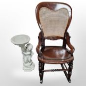 A Bristow bergere rocking chair and a composition statue