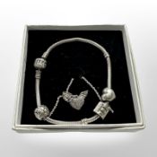 A Pandora silver charm bracelet, and a further Pandora winged heart pendant on chain,